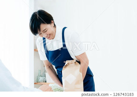 A female home helper arranging ingredients on a table A female home helper arranging ingredients on a table 126743183
