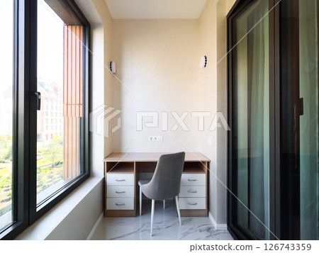 A modern minimalist corner home office that maximizes natural light for productivity and comfort 126743359