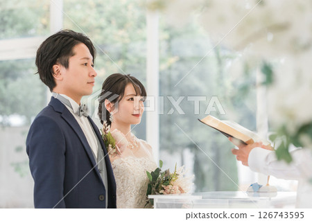 新娘和新郎在教堂或教堂的牧師面前宣誓（婚禮） 126743595