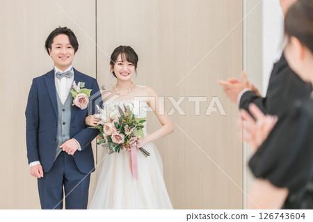 新娘和新郎與賓客和參與者一起走過婚禮大廳（愛心過道、教堂、小教堂） 126743604