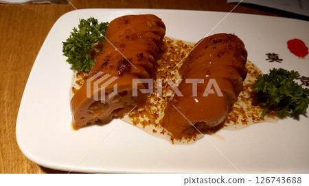 Lotus root in sweet and sour sauce in pieces on a plate 126743688