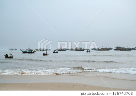Vietnamese fishing ships and traditional round basket boats with fishermen at sea in fishing village in Vietnam 126743708