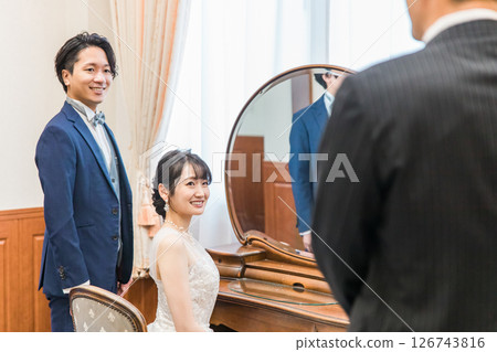 新娘和新郎在婚禮場地的新娘房和等候室與工作人員、經理和父親交談 126743816