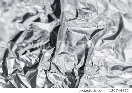Crumpled silver-colored foil surface showcasing its intricate texture 126744872