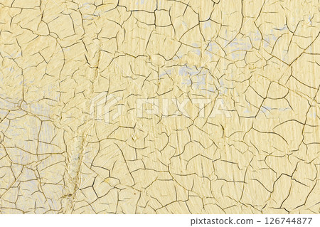 Close-up view of cracked yellow paint revealing a textured surface Close-up view of cracked yellow paint revealing a textured surface 126744877