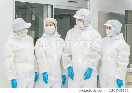 Male and female staff working in a manufacturing plant wearing protective clothing and clean wear Male and female staff working in a manufacturing plant wearing protective clothing and clean wear 126745421