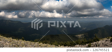 A sweeping view of rolling mountain ranges under a cloud-filled sky. A sweeping view of rolling mountain ranges under a cloud-filled sky. 126745521