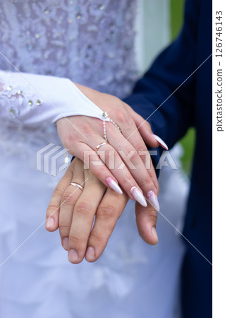 Romantic moment of newlyweds holding a beautiful flower arrangement, showing love and unity. Romantic moment of newlyweds holding a beautiful flower arrangement, showing love and unity. 126746143