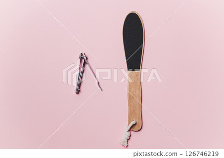 Wooden Heel scraper for foot peeling and steel nail cut on pink. Top view. 126746219