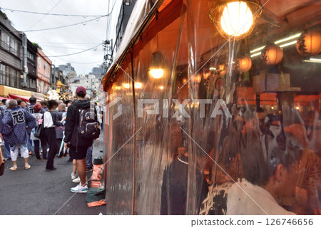 Hoppy Street is lined with drinking establishments covered in plastic sheets to protect from the rain. Hoppy Street is lined with drinking establishments covered in plastic sheets to protect from the rain. 126746656