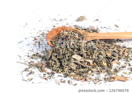 Dry green tea in wooden spoon on white background. Mix of healing herbs. Beverages, organic product and health. 126746676