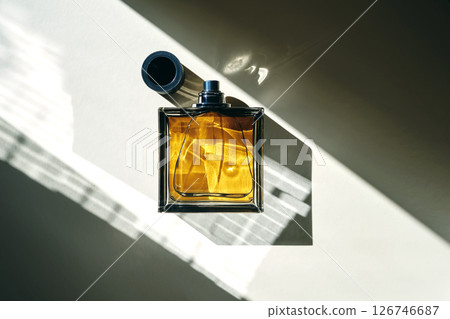 Perfume bottle in the rays of bright sun with beautiful highlights. 126746687