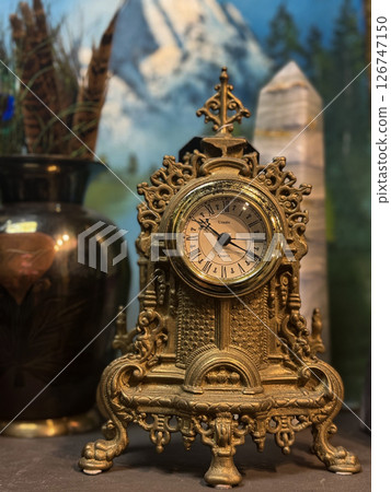 Antique Ornate Gold Clock with Roman Numerals on Display Antique Ornate Gold Clock with Roman Numerals on Display 126747150
