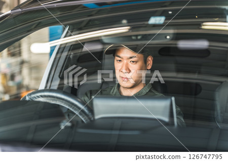 一名男性汽車修理工正在檢查汽車內部 126747795
