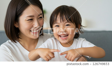 Mother and child playing together on the sofa 126749653