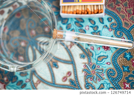 Twisted marijuana cigarette in a special flask 126749714