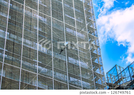 Yokohama cityscape in Japan. Apartment building repairs and inspections, scaffolding and protective nets. Satellite antennas outside the nets... Yokohama cityscape in Japan. Apartment building repairs and inspections, scaffolding and protective nets. Satellite antennas outside the nets... 126749761