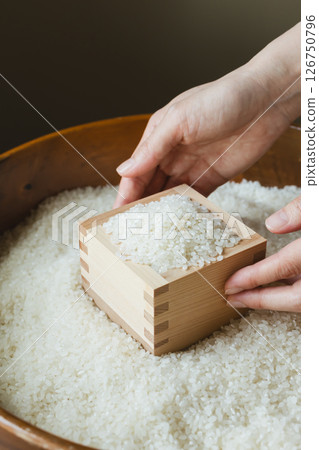 Rice in a wooden box and a woman's hand 126750796