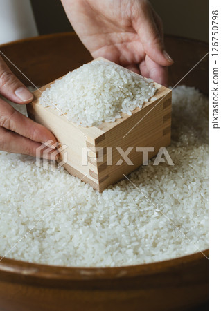 Rice in a wooden box and a woman's hand 126750798
