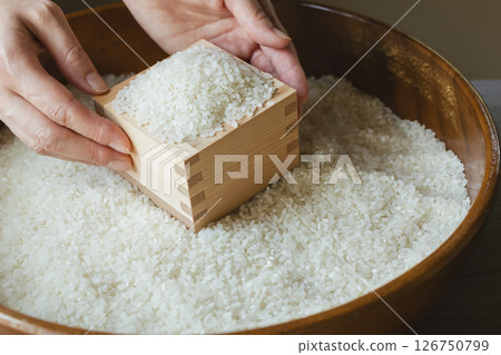 Rice in a wooden box and a woman's hand Rice in a wooden box and a woman's hand 126750799