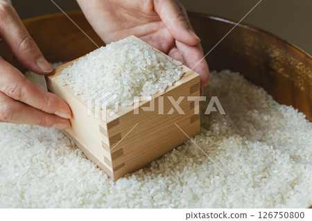 Rice in a wooden box and a woman's hand Rice in a wooden box and a woman's hand 126750800