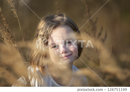 Portrait of a beautiful little girl in meadow grasses. Portrait of a beautiful little girl in meadow grasses. 126751199