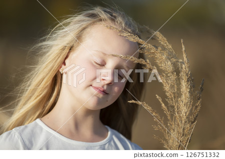 Beautiful little blonde girl with a bouquet of herbs.Child in a beautiful summer field. Beautiful little blonde girl with a bouquet of herbs.Child in a beautiful summer field. 126751332