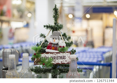 A souvenir snowman hangs on a small Christmas tree in the store. 126751344