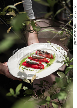 Portion of baked pepper appetizer with small fish 126751420