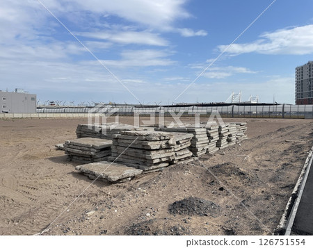 Construction Site Featuring Stacked Concrete Slabs Surrounded by an Urban Environment 126751554