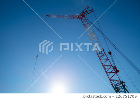 A crane extending into the blue sky 126751709