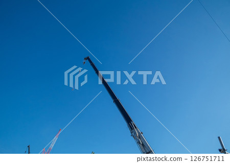 A crane extending into the blue sky A crane extending into the blue sky 126751711