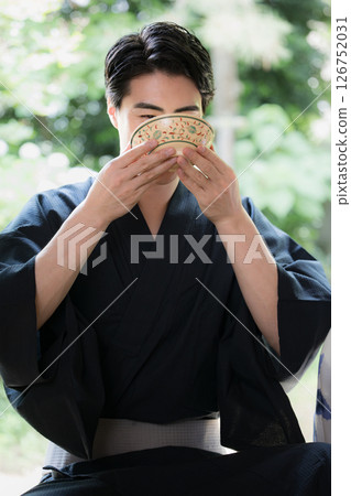 一名男子在陽台上喝茶。旅行或旅館的圖片。抹茶體驗。 126752031