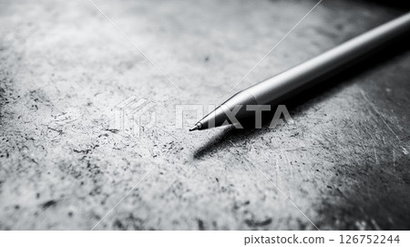 Metallic pencil, magnetic stylus on grey textured desk surface. Monochrome minimalist image with writing tool. Education, business, planning concept.  126752244