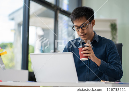 Businessman using laptop computer in office. Happy man, entrepreneur, small business owner working online. 126752331