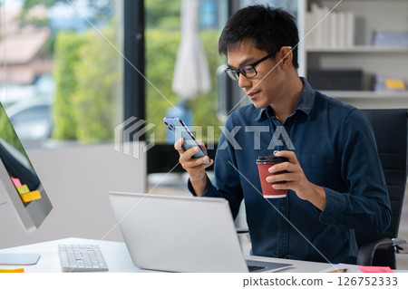 Businessman using laptop computer in office. Happy man, entrepreneur, small business owner working online. 126752333