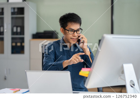 Male businessman talk mobile phones and working on laptop computers, online business, work from home, teleworking concept. Male businessman talk mobile phones and working on laptop computers, online business, work from home, teleworking concept. 126752340