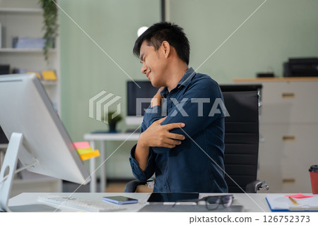 Male businessman is doing a stretchy posture due to sitting in the office for too long, office syndrome concept. 126752373