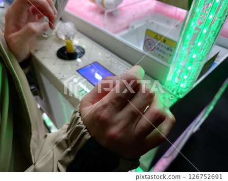 Woman's hand playing with a crane game Woman's hand playing with a crane game 126752691