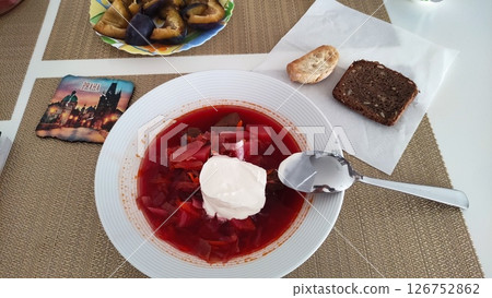 Borscht with sour cream, bread, and prague souvenir on table 126752862