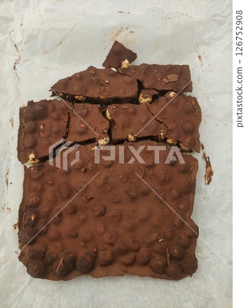 Homemade chocolate brownie with hazelnuts broken into pieces on baking paper 126752908
