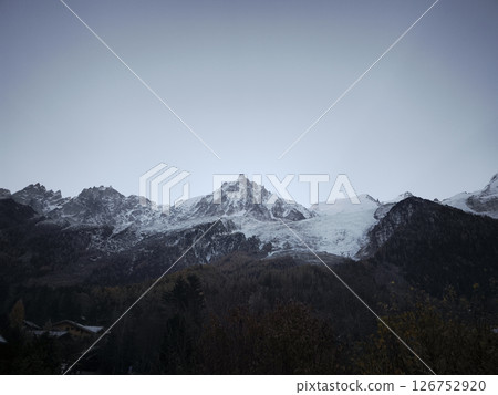 Majestic snow covered mountains rise against a clear sky, showcasing the serene beauty of chamonix and aosta in late autumn 126752920