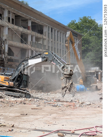 Demolition of Shopping centre Offices by an Industrial Grab Crusher Hydraulic Excavator 126753093