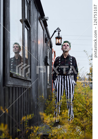 A Stylish Portrait Featuring a Person in Striped Pants Set Against a Vintage Cabin Backdrop 126753107