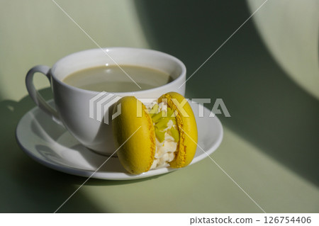 Green latte matcha with yellow macaron dessert on pastel background with creative deep shadows. Concept of holiday breakfast morning tea drink. Cozy minimalist superfood vibrant colors healthy eating 126754406