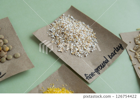 Raw fine ground barley porridge with text in paper. Refill product format eco-friendly living. Filling reusable container Whole spelt grain species. High protein fiber-rich vegan plant based food 126754422