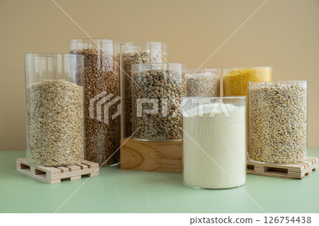 Refillable glass jar with raw grain porridge. Copy space Refill product format eco-friendly living. Filling reusable container Whole spelt grain species. High protein fiber-rich vegan plant based food Refillable glass jar with raw grain porridge. Copy space Refill product format eco-friendly living. Filling reusable container Whole spelt grain species. High protein fiber-rich vegan plant based food 126754438