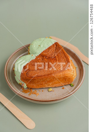 Delicious fresh croissant topped with Matcha Green Tea flavor Ganache on plate. Creation unique heart shape bakery. Puff pastry holiday love gift present idea Valentine's day Delicious fresh croissant topped with Matcha Green Tea flavor Ganache on plate. Creation unique heart shape bakery. Puff pastry holiday love gift present idea Valentine's day 126754488