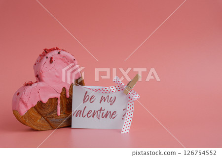 valentine's day BE MY VALENTINE saying caption on greeting card Delightful heartshaped pastry croissant treat, beautifully topped with colorful frosting galore. Copy space. Food experimentation viral 126754552