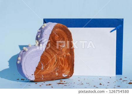 Empty paper note card template mock up Heart shaped blueberry flavor croissant on blue background with copy space. Puff pastry new trendy sweet dessert bakery. Creamy dough 126754580